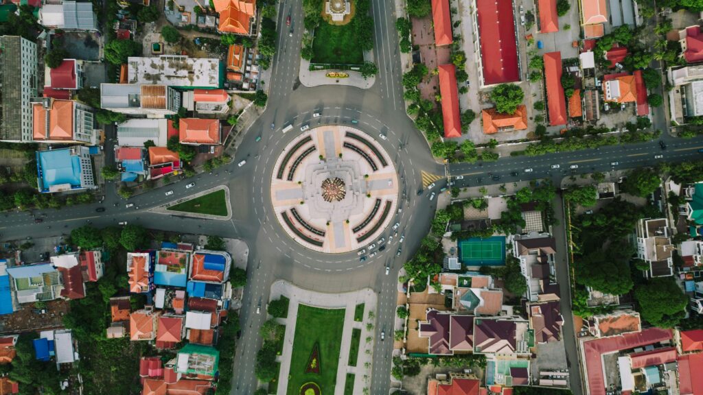 Stunning aerial view of a vibrant roundabout in Phnom Penh, Cambodia with colorful buildings and streets.