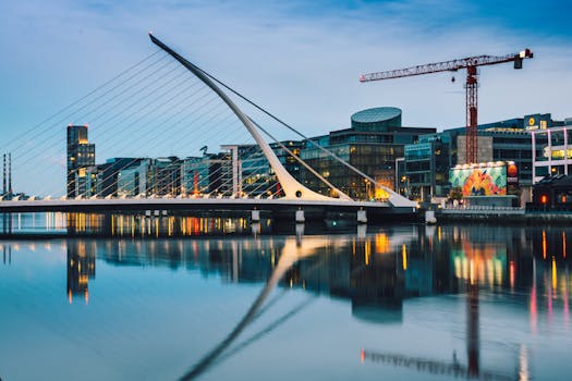 Stunning twilight view of the Samuel Beckett Bridge and Dublin skyline reflecting in the River Liffey.